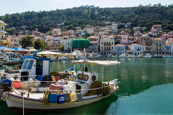 A photo of the port of Gytheio with small fishing boats and a part of the settlement in the background.