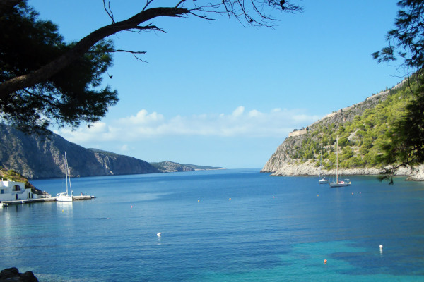 The blue sea and the light blue sky with the green coast at a bay of Kefalonia island.