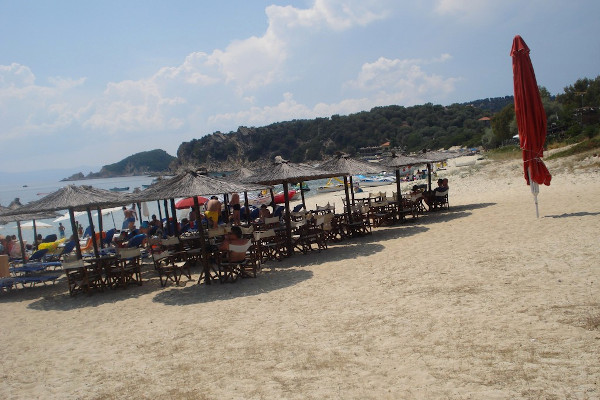 The umbrellas and the sunbeds of a beach bar at the Alykes beach of Ammouliani.