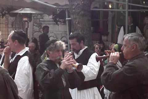 People playing musical instruments and other participants of the Arachova-Saint George celebration.