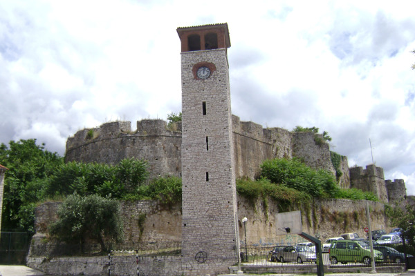 The Clock Tower of Arta in front of the walls of the Byzantine Castle of the city.