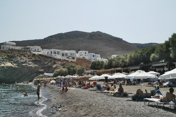 A photo showing people on sunbeds at the beach of Livadi on Αstypalaia.