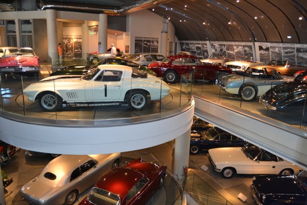 Two well-lit floors of old but shiny cars of different styles. 