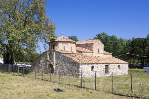 The exterior of St. Demetrius Church in Avlonari, Evia by a large tree.