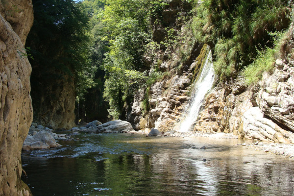 A waterfall in the «Panta Vrechei» Gorge of Evritania - rock, water, and trees.