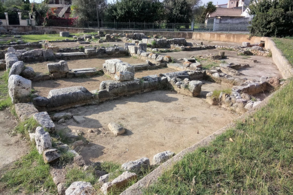 Stones in the shape of Isis Temple's foundation surrounded by grass, in Eretria.