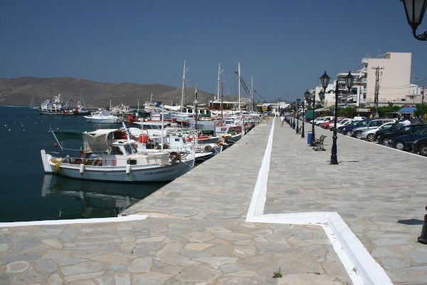 The seafront promenade of Karystos with many fishing and sailing boats anchored by the coast.