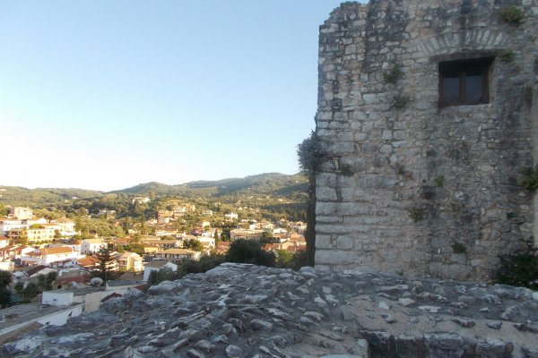 Kassiopi's grey-stone castle with weeds growing on its cracked walls.