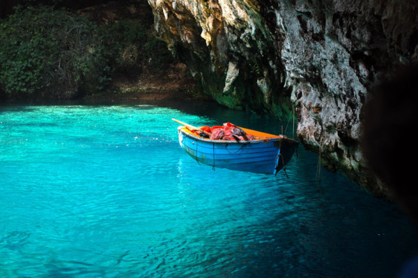 A guiding boat in the turquoise waters of the Melissani Cenote in Sami of Kefalonia.