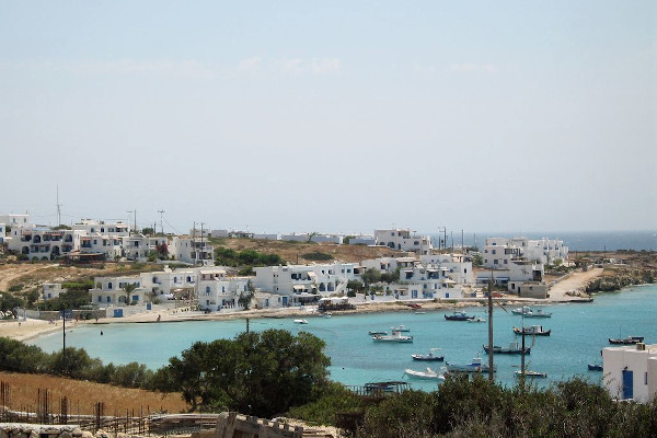 An overview of the Chora of Ano Koufonissi and the small bay with numerous boats in front of it.