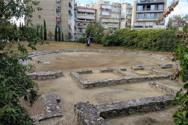 The remains of the ancient theatre of Larissa with blocks of apartments in the background.