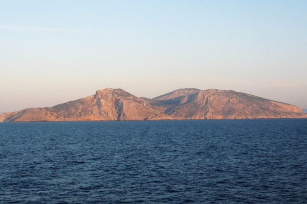 An overview of the uninhabited island of Keros - a huge rock shining in a setting sun.