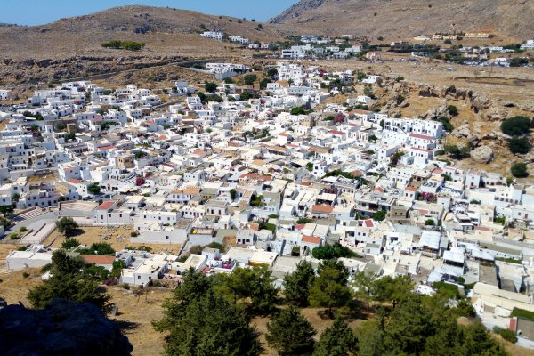 An aerial photo of Lindos full of white houses in a barren landscape.
