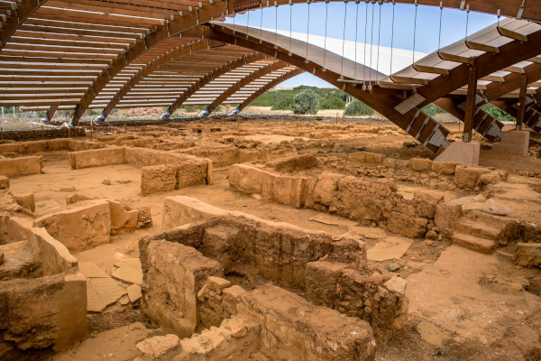 The remains of the Archaeological Site of Malia under a protective overhanging ceiling.