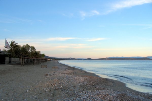 Some facilities built on Schinias beach. The beach has small pebbles and sand.