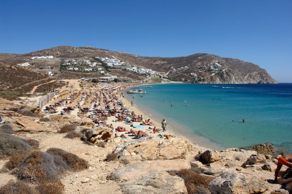 Elia Beach, Mykonos, is covered with umbrellas, has turquoise waters and is surrounded by dry hills.