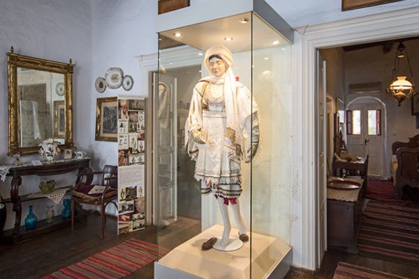 A mannequin in traditional attire in house with vintage and classic items and decoration.