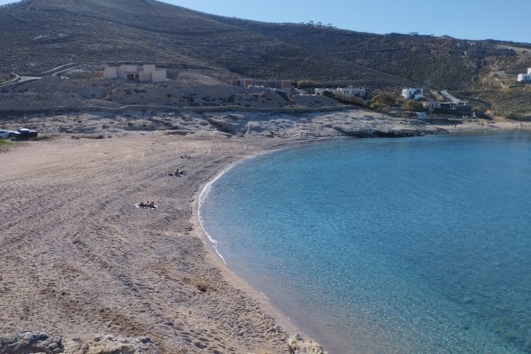 A picture showing Mirsini beach, it's surroundings and the colorful water.