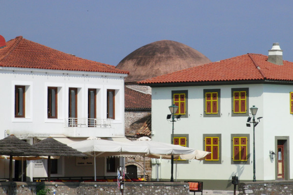 The building of Fethiye Mosque of Nafpaktos can be seen behind two other buildings.