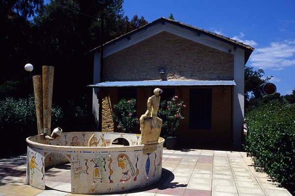 A circular fenced area with drawings and a small statue in the yard of Stathmos Childhood Museum, Nafplio.