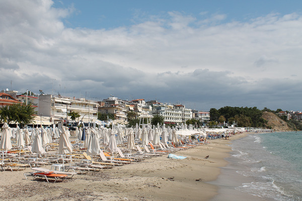 Numerous umbrellas and sunbeds on the beach of Nea Kalliktatia beach.