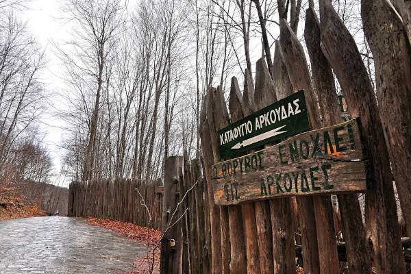 The shelter's wooden fence among a winter landscape, and a sign asking for people to not be noisy.