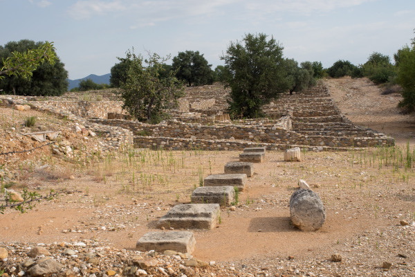 Ruins at the archaeological site of ancient Olynthos among trees and bushes.