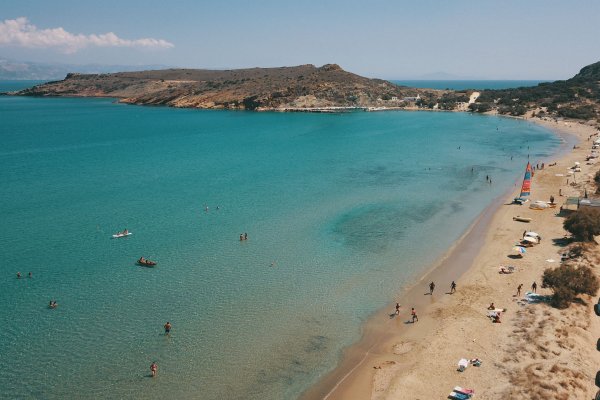 The turquoise waters and the clay-rich sand of Kalogeros Beach, Paros.