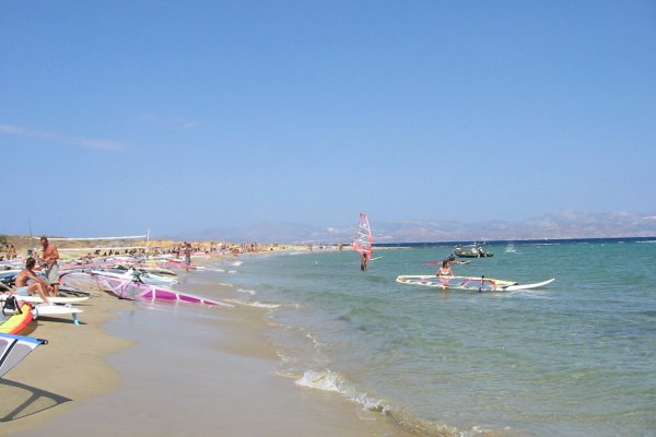 Several colorful surfs and a few people on Nea Chrisi Akti Beach.