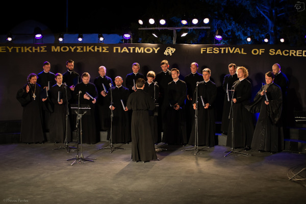 A choir in black clothing on the stage of the  Patmos Sacred Music Festival.