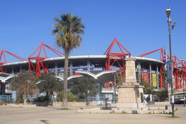 The exterior of the gigantic Karaiskakis Stadium in Piraeus supported by massive red trestles.