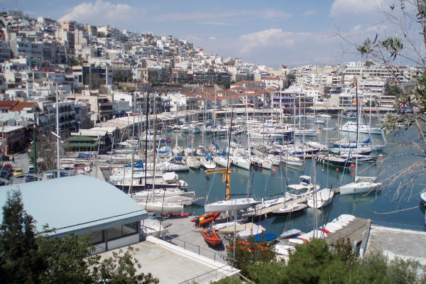 An overview of the promenade of Mikrolimano and the marina with numerous sailing boats.