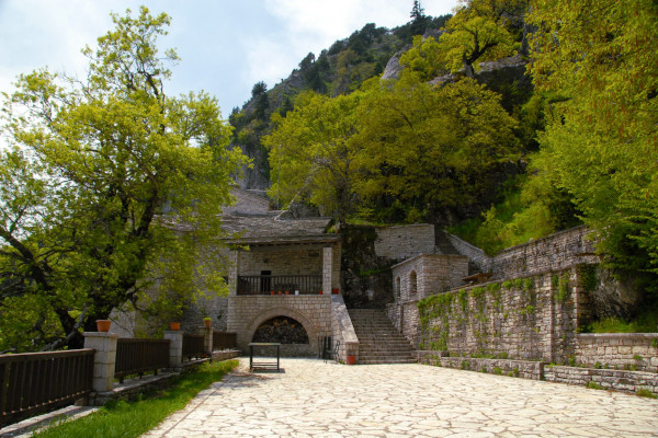 Picture from the yard of the Panagia Pelekiti Monastery showing stone-built facilities and the surrounding vegetation.