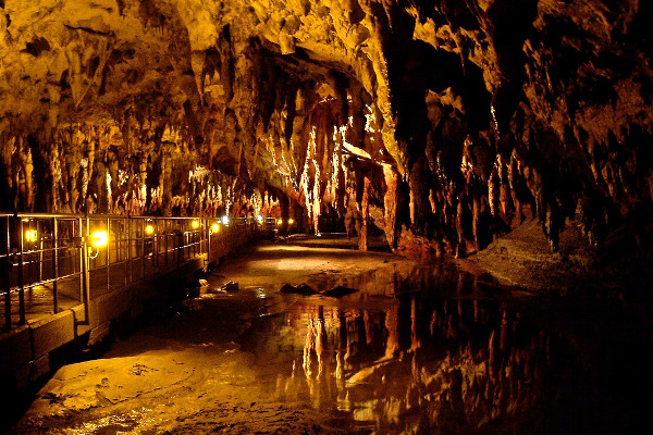 The artificial path of the visitable part of Aggitis Cave among numerous stalactites and stalagmites.