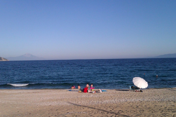 A photo depicting a family to enjoy the sun and the water at the Kampos (Ladhario) beach of Pyrgadikia.