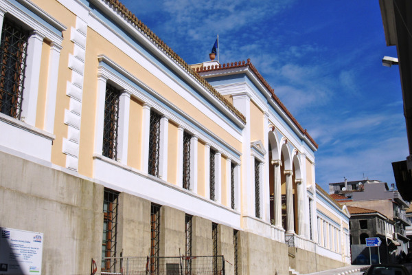 The Archaeological Museum of Pyrgos is a neoclassical building with a tiled roof and ochre colors.