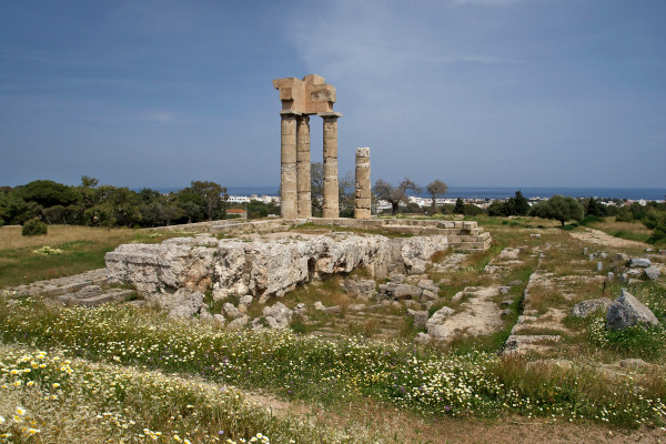 Remains of the temple of Apollo at the Acropolis of Rhodes on a grassy hill.