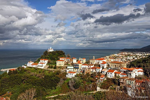 A panoramic picture of the town of Karlovasi in Samos with a church on top of a hill.
