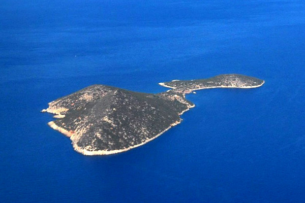 A panoramic photo depicting the Samiopoula Island in the blue sea.