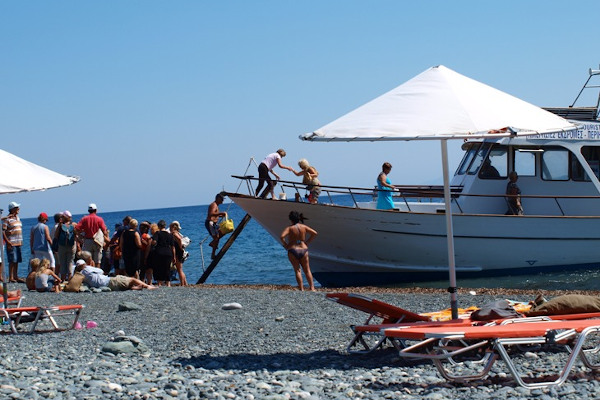 Tourists embarking on a daily cruise boat at one of the remote beaches of Samothraki.