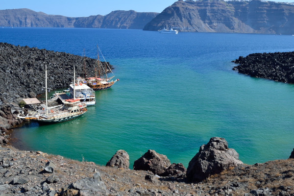 Boats anchored at the rocks of Nea Kameni during a daily excursion.