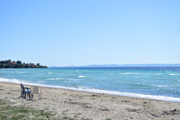 A photo showing some plastic chairs and a part of the beach of Nikiti of Halkidiki.