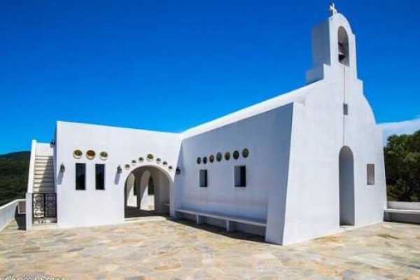 Agios Alexandros Chapel, Skiathos, is a perfectly white church with Greek-island architecture against a blue sky,