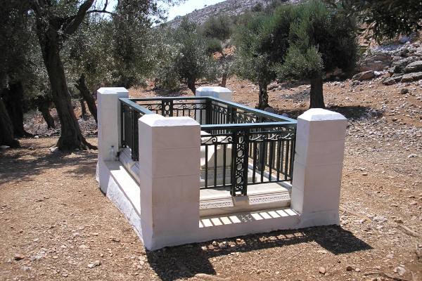 Rupert Brooke's white-marble tomb is fenced and surrounded by olive trees and rocks.