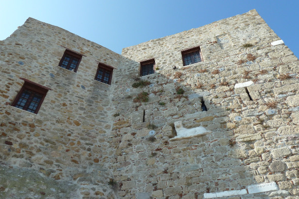 The high stone-built walls of St. George Monastery of Skyros and a few windows.