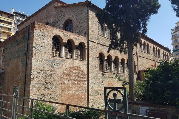 A brick-built Byzantine church with a few arched windows among blocks of apartments.