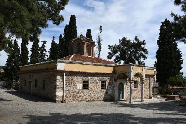 The small Vlatadon monastery with a portico and a dome in the middle of a spacious yard.