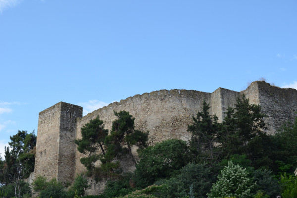 A picture showing the walls of the castle among the lush vegetation of the acropolis of Trikala city.
