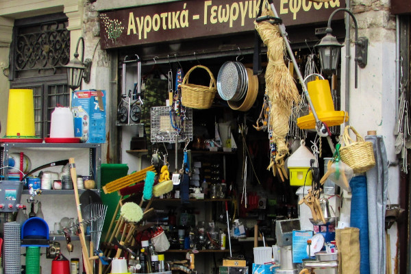 A traditional shop with many commodities on shelves and other hanging on the walls.