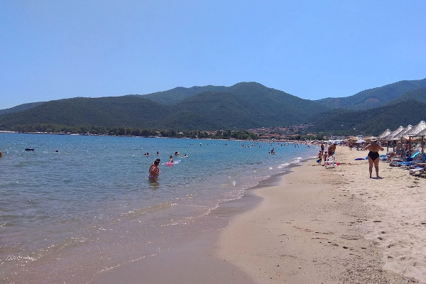 A photo depicting people, umbrellas, and sunbeds at the Stavros of the Volvi area of Thessaloniki.